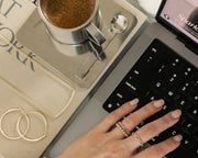 Woman typing on laptop wearing rings