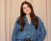 Macy Shutan is standing in front of a beige curtain backdrop.
