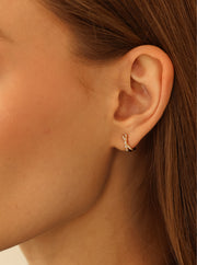 Close-up of an ear wearing a small earring with a blurred background