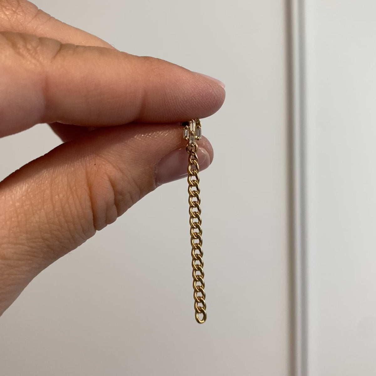 video of yellow gold earring in hand