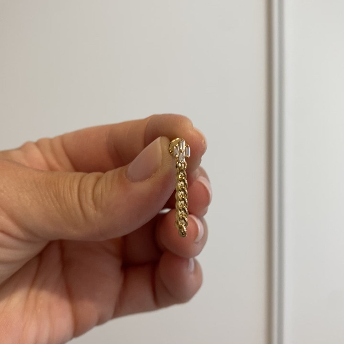 video of yellow gold earring in hand